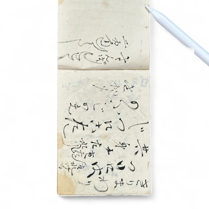Edo-Meiji handwritten Japanese notebook with hentaigana cursive script on washi paper, tied with string binding.