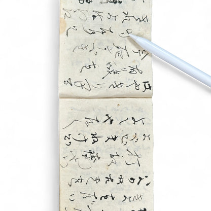 Edo-Meiji handwritten Japanese notebook with hentaigana cursive script on washi paper, tied with string binding.