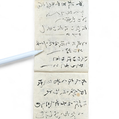 Edo-Meiji handwritten Japanese notebook with hentaigana cursive script on washi paper, tied with string binding.