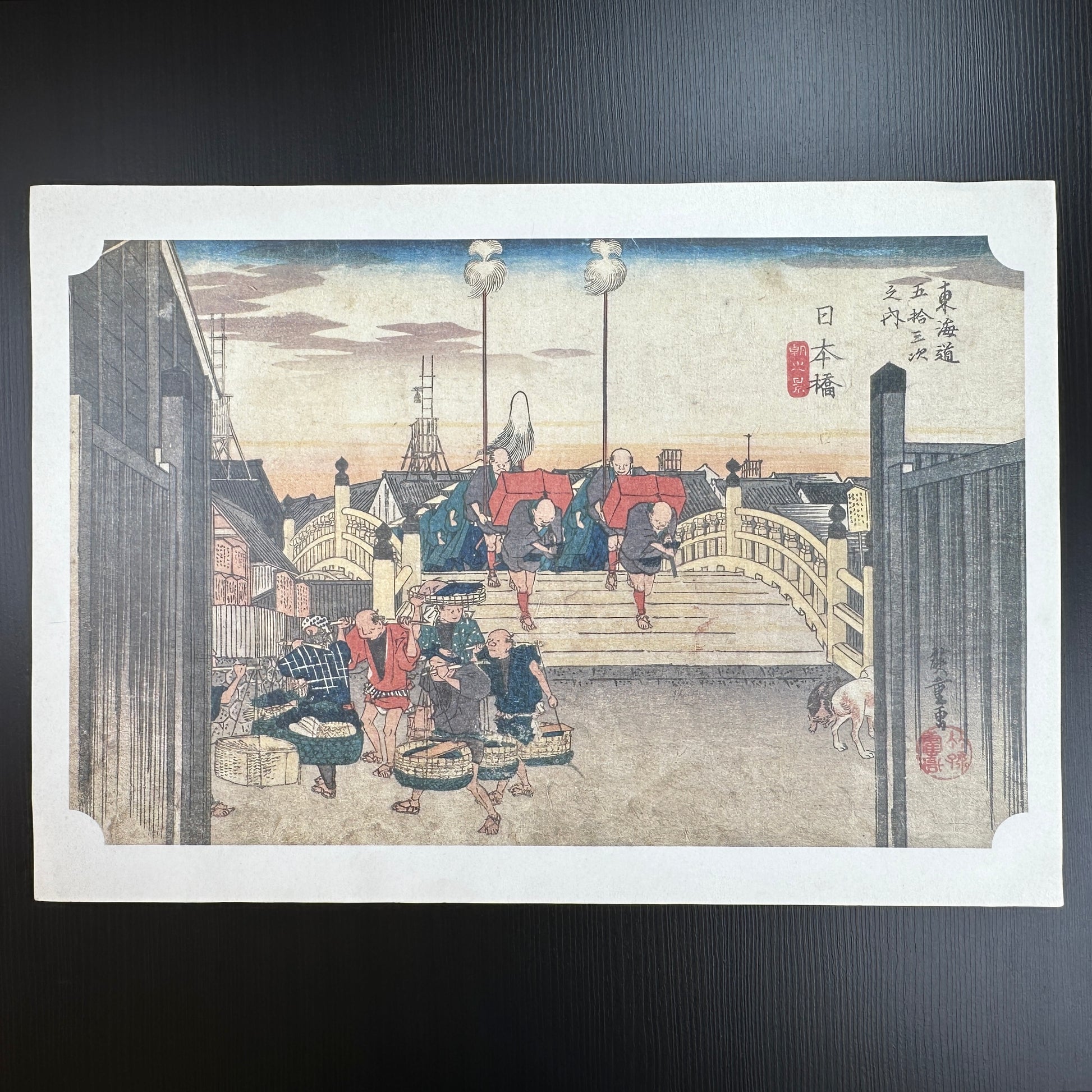 Utagawa Hiroshige woodblock print Nihonbashi Morning Scene from The Fifty-Three Stations of the Tōkaidō, travelers on bridge at sunrise, Japanese ukiyo-e reproduction.